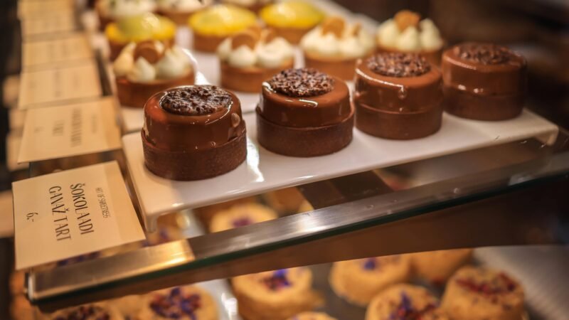 Pastries and tarts lying in a line in a glass counter
